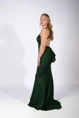 Vestido largo de fiesta color fucsia, con escote halter y corte sirena que se ajusta al cuerpo hasta la rodilla y se ensancha hacia el ruedo.