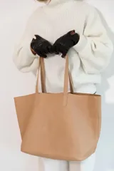 Bolso tote de cuero color tostado, con doble asa de hombro y diseño minimalista. Incluye un bolsillo separador extraíble.