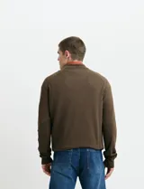 Cardigan de algodón con cuello alto y cierre frontal completo. Presenta mangas largas tipo ranglan y bolsillos laterales de ribete.