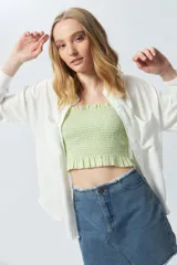 Crop top cuadrillé sin mangas con volados en la cintura.