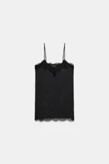 Top lencero negro de satén con escote en pico y tirantes finos regulables. Presenta detalles de aplicaciones de encaje floral en el escote y en el bajo.