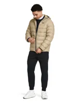 Campera puffer con capucha Under Armour, color beige, con cierre frontal, bolsillos laterales con cremallera y logo de la marca en el pecho. Cuenta con tecnología UA Storm repelente al agua y aislamiento térmico.