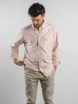 Camisa de corte regular confeccionada en tejido Oxford de algodón, con diseño de rayas verticales en tonos claros. Presenta cuello con botones, cierre frontal abotonado, mangas largas y un bolsillo en el pecho con logo bordado.