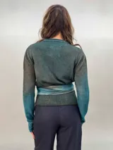 Buzo de punto confeccionado en 100% lana merino con efecto degradé en tonos azules. Presenta un diseño versátil con lazos largos que nacen de la cintura alta para anudar de diferentes formas, mangas entalladas con ojal para el pulgar y cuello redondo.