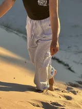 Pantalón de tela rayada rosa y blanco, de corte amplio y cintura elastizada.