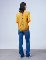 Sweater amarillo de tejido fino con espalda abotonada y mangas 3/4 con puño elastizado.