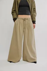 Pantalón chino de tiro bajo, color negro, pierna muy ancha, con cintura elástica con cordón ajustable y pinzas en la parte superior.