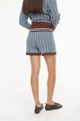 Short de punto tejido, color beige con detalles rayados en la cintura y los bordes inferiores, de tiro medio con cordón ajustable.