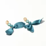 Par de caravanas con cuentas de colores y lazo de tela celeste.