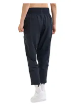 Pantalón deportivo Under Armour de corte al tobillo, color negro, con cintura elástica de talle alto y cordón interno. Presenta bolsillos laterales y detalles reflectantes en los laterales de las piernas.