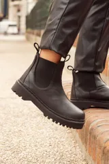 Botas de cuero negro con elástico a los lados, suela de cuero y forro de cuero vacuno.