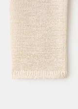 Chaleco de punto grueso color beige, con diseño recto, cuello redondo y sin mangas.