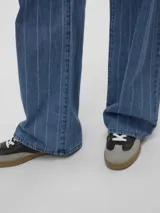 Jean wide fit de tiro alto color azul denim con rayas verticales blancas, cierre de botón y cremallera. Confeccionado en tejido de sarga de algodón.