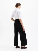 Pantalon de corte wide leg y largo completo, confeccionado en tejido de algodon con elastano. Presenta tablas en la cintura delantera, cierre metalico, ganchos pantaloneros y presillas con broches snap niquelados. Incluye bolsillos laterales y traseros.