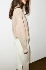 Jersey de punto grueso color beige, con cuello redondo y manga larga, de diseño amplio y acabados en rib.