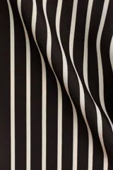 Pantalón de tiro alto con cintura elástica, piernas rectas y diseño estampado de líneas blancas que forman un marco geométrico en la parte inferior sobre fondo negro.