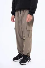 Pantalon cargo negro de corte holgado, con bolsillos laterales con solapa y puños elásticos en los tobillos. Cuenta con cintura elástica con cordón de ajuste.