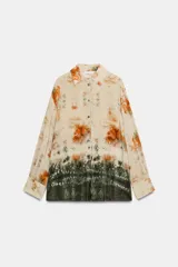 Camisa de manga larga con cuello solapa y cierre frontal con botones, con diseño tie-dye en tonos beige, naranja y verde oscuro en el sector inferior.