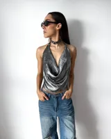 Top de fiesta color plateado con acabado metalizado, diseño halter con cuello drapeado y espalda descubierta.