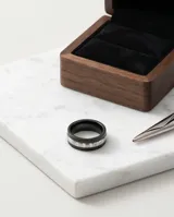Anillo de acero con banda central plateada texturizada y bordes en esmaltado negro.