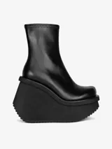 Bota negra de caña media con plataforma y cuña esculpida.