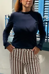 Remera de manga larga color azul marino, con cuello redondo y puños decorados con volados sutiles.