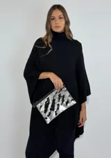 Clutch plateado con lentejuelas de doble cara que revelan diferentes colores al tacto. Acabado en cuero en los bordes y tira para mayor estructura.