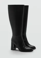 Bota de caña alta confeccionada en piel bovina, con diseño de punta fina y tacón bloque.