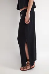Falda larga de corte recto y tiro bajo en color negro, confeccionada en tejido plano dobby con textura rústica de mezcla de lino y viscosa. Cuenta con un cordón ajustable en la cintura.