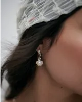 Aros de plata con diseño irregular, argolla articulada y dije colgante con perla de río engarzada.