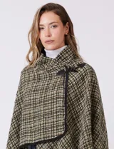 Ruana tejida de Jones New York con diseño a cuadros en tonos verdes y marrones. Presenta cuello alto, cierre frontal con botón tipo trenca y bordes con ribete negro.