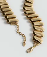 Collar corto de metal dorado con diseño de eslabones anchos y planos de acabado brillante. Cuenta con cadena extensible y cierre de mosquetón.
