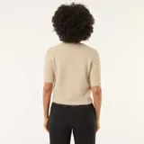 Sweater de punto de textura suave y acabado ligeramente peludo, color beige. Presenta cuello redondo, mangas cortas con terminación acanalada y diseño de corte recto.