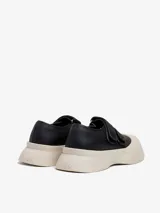 Zapato abierto de piel estilo bailarina con plataforma en negro. Cierre de dos tiras con velcro.