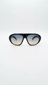 Lentes de sol tipo aviador oversized con armazón negro de acetato y cristales degradados en tonos azul y beige.