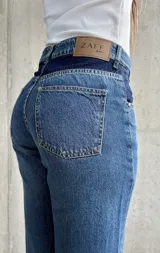 Pantalón de jean de tiro alto, color azul con detalles en azul oscuro en los bolsillos delanteros.