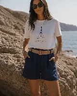 Short de lino color azul marino, de tiro alto, con bolsillos laterales y e incluye un cinto de rafia con hebilla redonda.