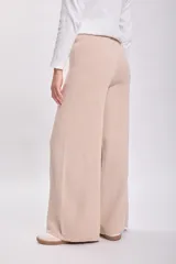 Pantalón de punto en color beige, de corte recto y tiro alto, con cintura elástica y diseño holgado.
