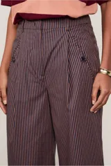 Pantalón de vestir de corte ancho, color borgoña con finas rayas verticales color beige. Presenta bolsillos laterales y traseros con botón.