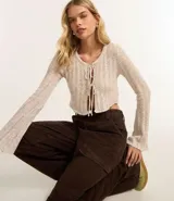 Pantalón wide leg de sarga color marrón chocolate, tiro alto, con bolsillos laterales tipo cargo y etiqueta con lettering en la cintura.