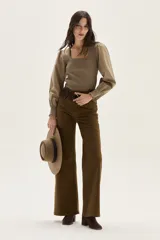 Top de calce ajustado color marrón, con escote cuadrado y mangas largas abullonadas de tela lisa. Los puños de las mangas son elastizados.