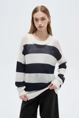 Sweater de tejido de punto calado con diseño a rayas horizontales en color blanco y azul marino, cuello redondo y mangas largas.