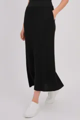 Falda midi negra de viscosa y lurex, con diseño de punto acanalado, corte recto y bolsillos laterales.