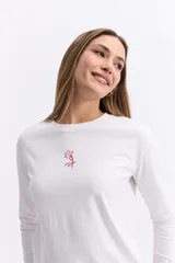 Remera de manga larga color negro, con silueta levemente boxy y largo a la cintura. Presenta una estampa lineal de una flor en el centro del pecho.