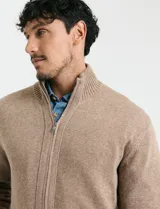 Cardigan de punto gris con cuello alto, cierre frontal de metal con doble cursor y bolsillos laterales. Presenta puños y cuello en tejido canalé.