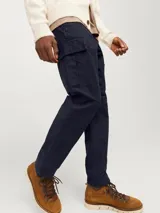 Pantalón cargo azul marino de corte relajado, con bolsillos traseros, frontales y laterales. Tiene cierre de gancho y cremallera, tiro medio y cordones en los dobladillos.