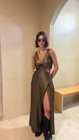 Vestido largo de crepé con acabado metalizado, escote en V profundo con detalle de aro central, aberturas laterales en la cintura y falda con tajo frontal.