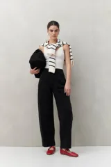 Pantalón de jean negro de tiro alto y corte amplio con pinzas frontales.