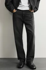 Pantalón de jean corte slim fit con efecto lavado, tiro medio, cinco bolsillos y cierre frontal con cremallera y botón.