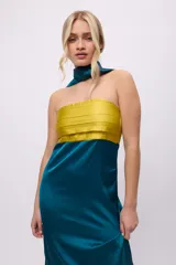 Vestido largo de satén negro con corpiño marrón con tablas y bufandín al cuello.